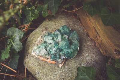 A teal green fluorite crystal on a rock.