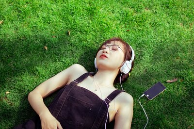 Young woman practicing nervous system calming outdoors with music therapy