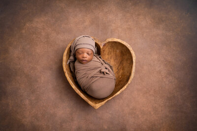 newborn photoshoot with baby in heart shaped bowl