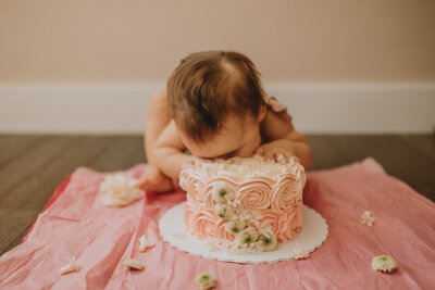 young baby girl with her face in a cake