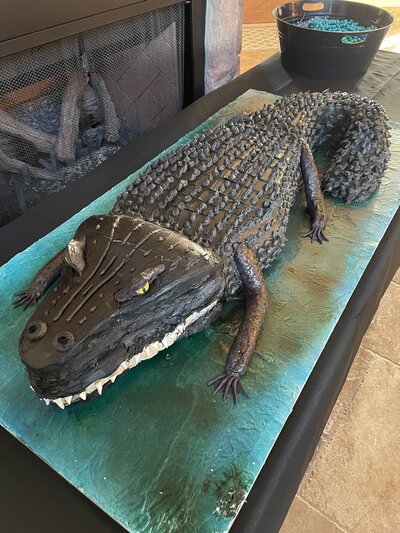 4 foot long alligator groom's cake . Chocolate cake with buttercream frosting; Rice Krispie treat legs; modeling chocolate teeth