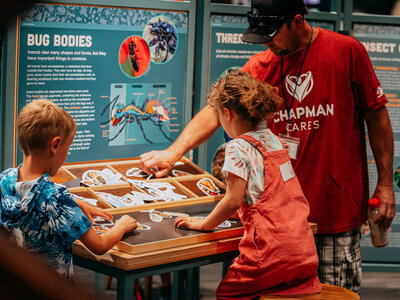 Foster Care volunteer playing with kids at the museum