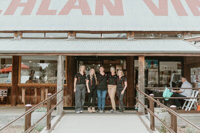 Team standing together outside a local event venue for a group photo by event photographer