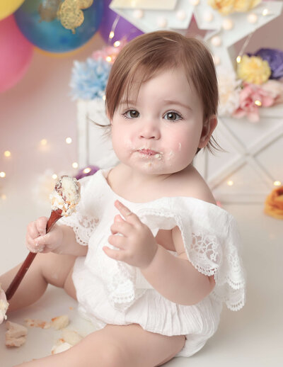 Adorable little girl at her cake smash at our Rochester, Ny studio.