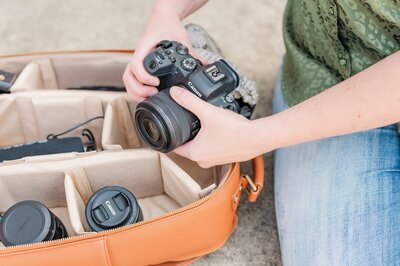 woman putting a camera into a camera bag