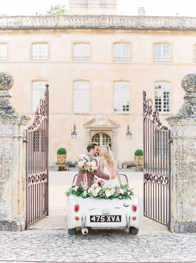 Florals line the back of this vintage car for the newlyweds.