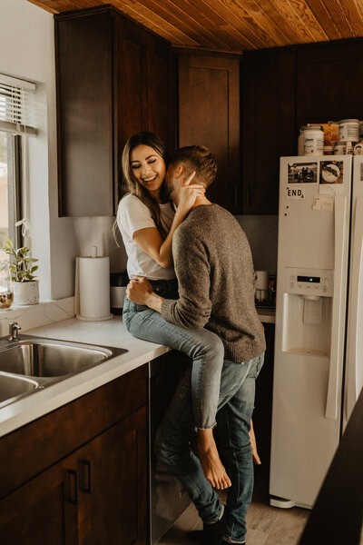 couple kissing in the kitchen for an engagement photoshoot