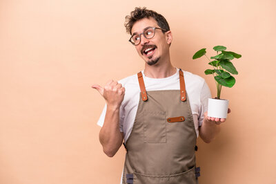 Male florist holding a green plant for brand photo session