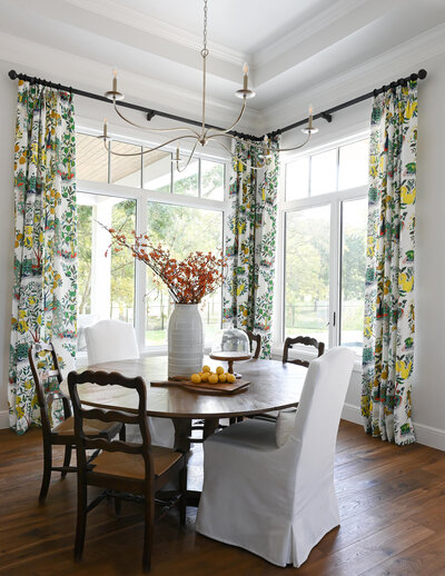 dining room with patterned curtains and large windows