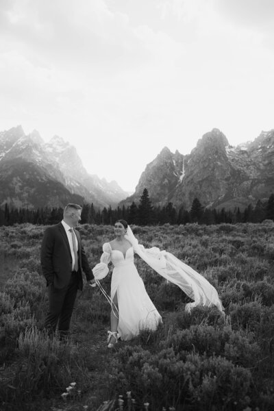 groom and bride standing next to their wedding cake at their wedding venue taken by jackson hole wedding photographer adrian wayment photo