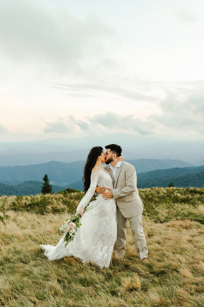 Photo of Bride and Groom kissing  at their elopement with the blue ridge  mountains in the background
