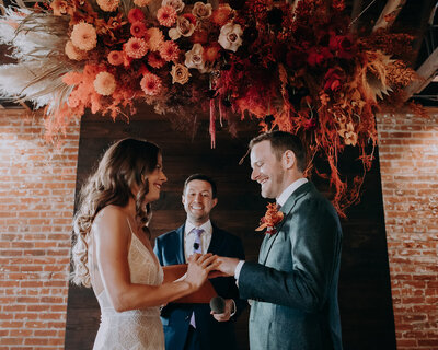 wedding ceremony at the St Vrain with large red and orange floral overhang