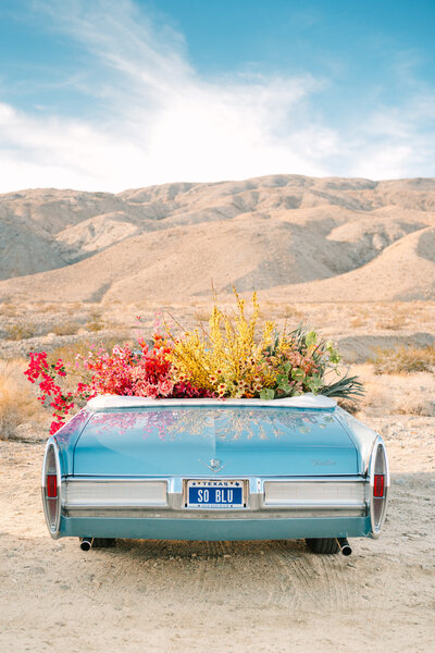 vintage blue convertible filled with flowers