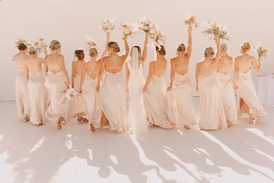 Bridal Party Walking Away with Bouquets Up in Celebration - Bre & Chris | Converted Basketball Court Wedding – Featured in Brides Magazine