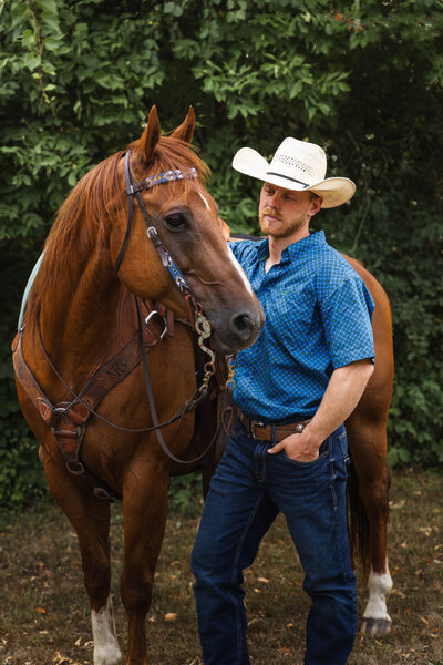 man standing next to horse