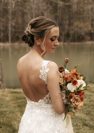 bride holding bouquet with lake in the background