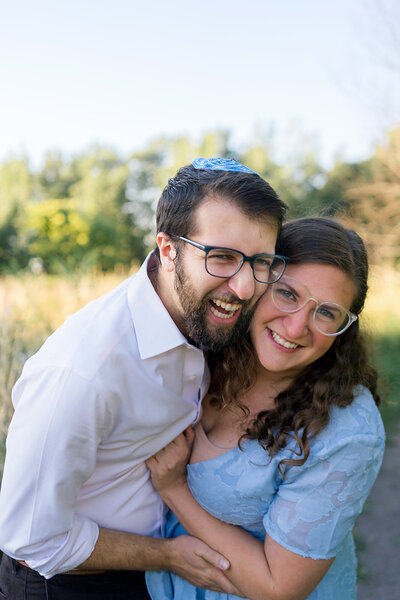 Jewish Couple smiling in a field outside of Chicago in a Couples session with Eliana Melmed Photography