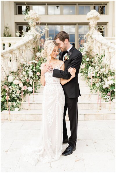 Bride and groom standing on flower covered steps in Alabama