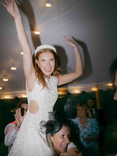 Bride on the shoulders of friend at Came House Wedding Reception