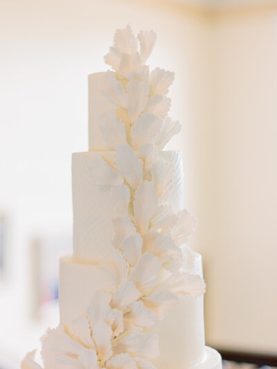 An all white, 3-tiered wedding cake with a cascading design