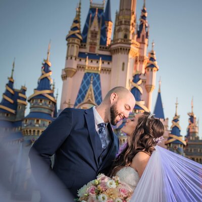 Bride and groom looking at each other in front of Cinderella's Castle