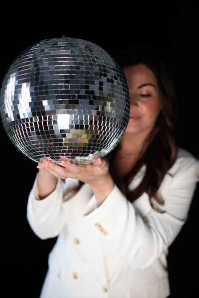 Woman smiling holding a disco ball