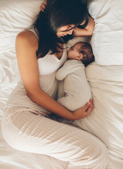 A mother cuddling with her infant. Showing the importance of working with a therapist for moms to address postpartum anxiety in Manhattan. Counseling for mothers can help whether you are trying to conceive, just had a baby, or have older kids.