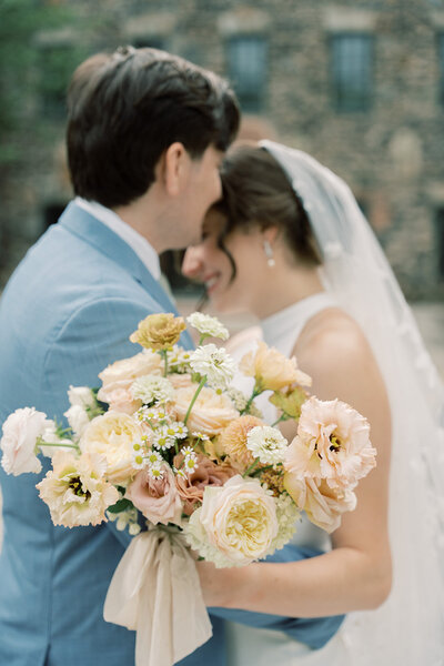 Fall bridal bouquet salmon, dusty rose pink, dahlias, butterfly ranunculus, cosmos, zinnias with tweed jacket,