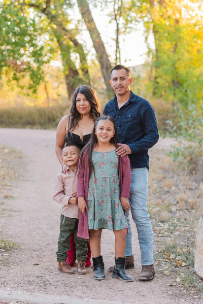 A family poses together along a light dirt path in Colorado Springs by Laramee Love Photography