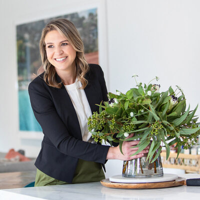 Real estate agent placing a vase on a kitchen bench