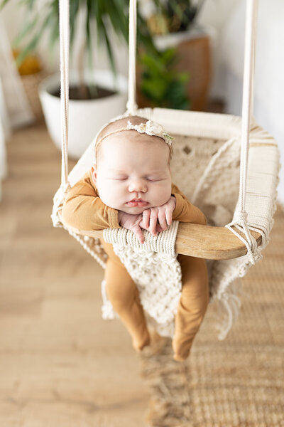 newborn sleeping in swing