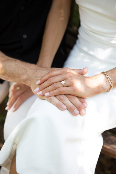 An Austin wedding photographer captures the intimate moment of a bride and groom holding hands on a bench.