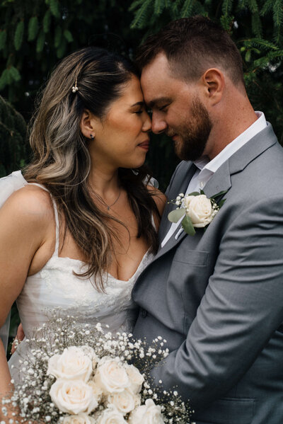 Bride and groom embrace each other with their foreheads