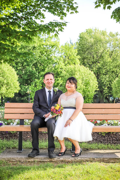 Bride and groom sitting on a bench together