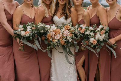 Fall inspired bridal bouquets of pink and orange, tied with green satin ribbon featured on Bronte Bride, an online Canadian wedding publication and resource.