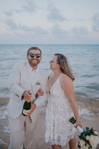 Destination wedding photographer captures bride and groom popping champagne