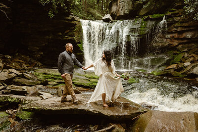 Bride and groom stand in front of waterfall during their West Vriginia