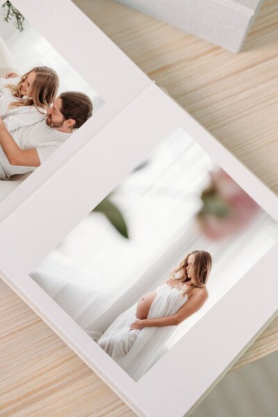 Album of maternity images displayed on table.