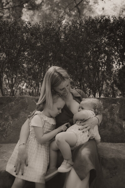 photo maman allaite bebe et sa fille se blottie contre elle jardin menton