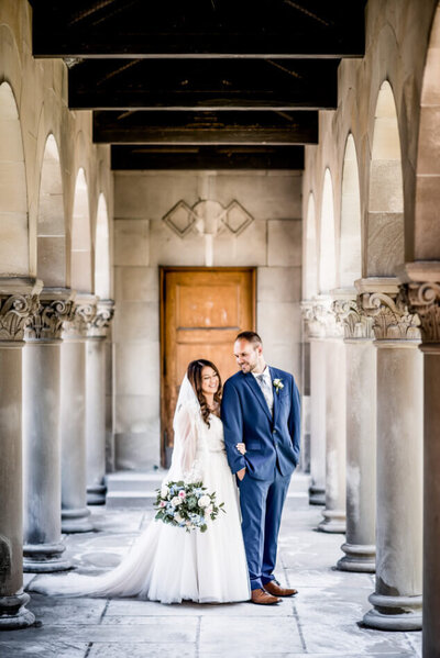bride and groom standing in columns of old chapel in cleveland ohio