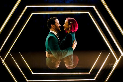 A couple hugging and about to kiss with a hexagon shaped light around them