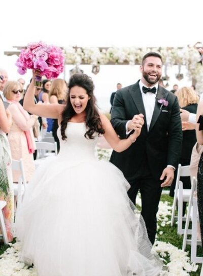 Bride and groom walking hand in hand down the aisle
