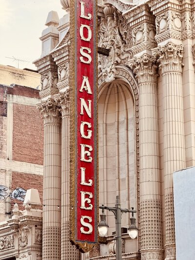 Historic Los Angeles Theatre building with red vertical sign, architectural detail featured in branding section of Jasmina Kimova’s contact page.