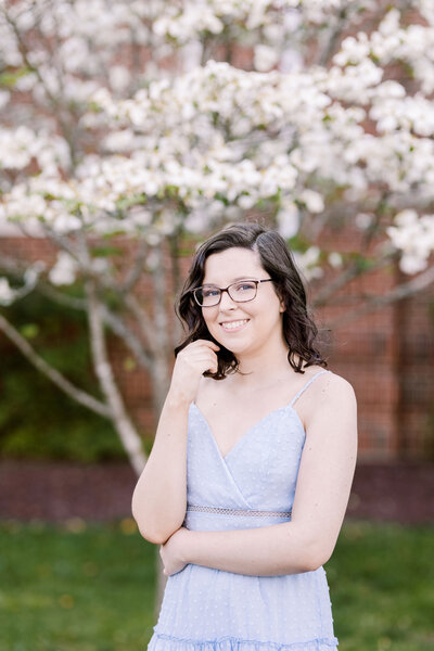 college senior standing in front of a white tree