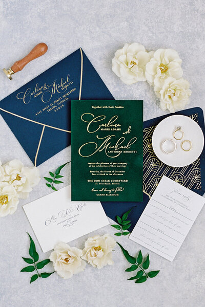 Luxurious wedding invitation suite with gold foil on green velvet invitations, sapphire blue envelope liners with gold foil accents, and hand calligraphed return addressing in gold. Created for a December wedding at Don Cesar Hotel, St. Pete Beach, FL.