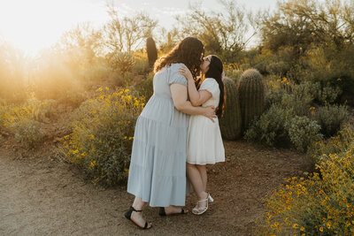 A couple with their arms around each other kissing 