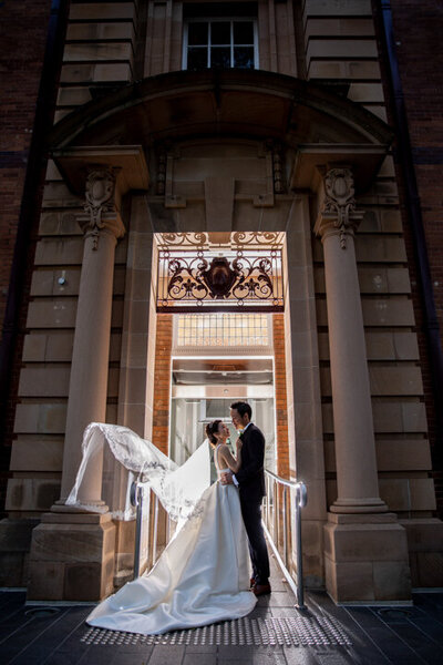 Wedding couple poses for their wedding photo shoot at the center of the doorway