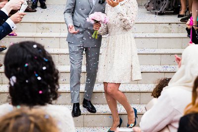 Wedding party on stairs being celebrated with confetti and flowers