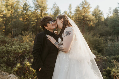 A newlywed person kissing their partner on the cheek 