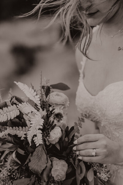 Bride showing off her ring holding her bouquet.